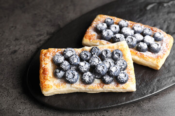 Poster - Tasty puff pastries with blueberries on grey table, closeup