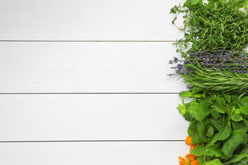 Wall Mural - Different aromatic herbs on white wooden table, top view. Space for text