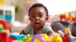 © Nany - Black baby playing with colorful toys, showing curiosity and joy