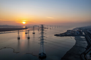 Wall Mural - Ansan-si, Gyeonggi-do, South Korea - December 8, 2021: Aerial and sunrise view of transmission towers on Sihwa Lake