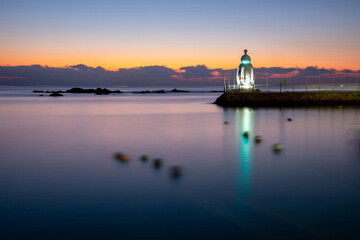 Wall Mural - Yeonhwa-ri, Gijang-gun, Busan, South Korea - December 5, 2021: Long exposure and dawn view of sea and baby bottle lighthouse on breakwater