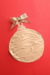 Poster - Christmas ball made of skin foundation on red background, top view