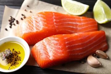 Canvas Print - Pieces of fresh salmon, garlic, lime, oil and spices on table, closeup