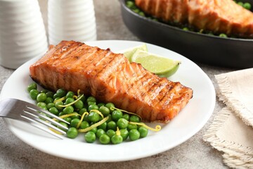 Delicious grilled salmon fillet served on grey textured table, closeup