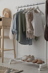 Poster - Rack with clothes, shoes and standing desk near white wall