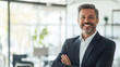 © UniqGraphicX - Confident businessman smiling and standing in a office. Middle Aged Businessman wearing a Suit showing positivity, growth, and success.