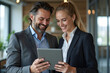 © Amir Bajric - Business colleagues sharing a laugh over a tablet. Male executive and young female employee.