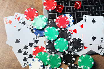 Canvas Print - Poker chips, laptop, playing cards and dices on wooden table, flat lay. Online game