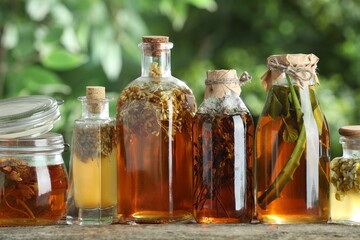 Wall Mural - Different natural tinctures on wooden table outdoors, closeup