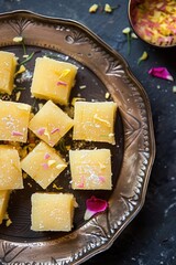 Delicious Yellow Square Treats with Sugar and Flowers on Decorative Dish.