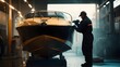 © purrfiction - Worker polishing a boat in a workshop.