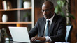 © EmmaStock - Businessman working on a laptop at a desk