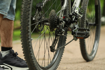 Wall Mural - Man near bicycle with modern action camera outdoors, closeup