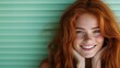 © JoxyAimages - A vibrant portrait of a young redheaded woman with freckles, smiling broadly, captured against a mint green background, showcasing natural beauty and happiness.