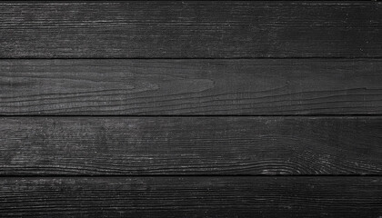 Black wooden planks, showing the intricate grain and texture of the wood. The dark color and rustic feel of the planks provide a simple, yet elegant backdrop.