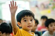 © GoodandEvil - Smiling boy in yellow shirt raising hand in classroom.