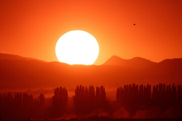 Closeup of the sun setting over a mountain