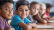 © Darcraft - Happy boy smiling while sitting at a desk in a classroom Children sitting at desks First day of school