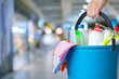 © natali_mis - Management holding bucket with cleaning supplies .