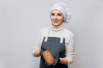 Happy woman baker in apron hold fresh multigrain bread from seeds on white background