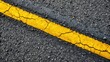 © Four888 - A broken yellow dashed line stretches diagonally across a rough, gray asphalt road, dividing the pavement and creating a sense of caution and guidance.