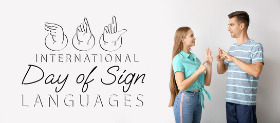 Wall Mural - Young deaf mute couple using sign language on white background