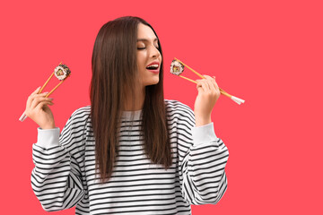 Wall Mural - Young woman with sushi on red background