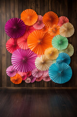 Wall Mural - A large photo booth backdrop , featuring a gradient of pink, orange, and green paper fans against dark wood paneling, creating a vibrant and celebratory atmosphere.Copy space,flat lay.