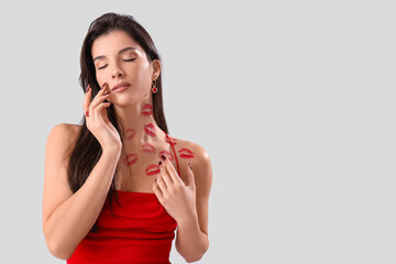 Sticker - Attractive young woman with lipstick kiss marks on her neck against light background