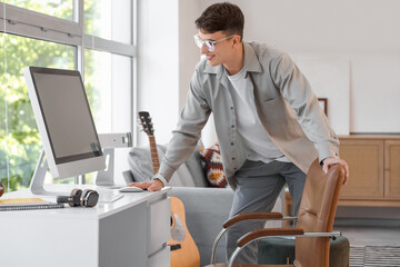 Wall Mural - Young man near computer on desk at home