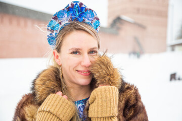 Portrait of a beautiful Russian girl in a kokoshnik and traditional dress