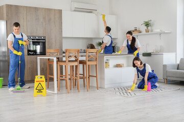 Canvas Print - Team of young janitors cleaning in kitchen