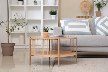 Sticker - Interior of stylish living room with comfortable sofa, coffee table, shelving unit and houseplant