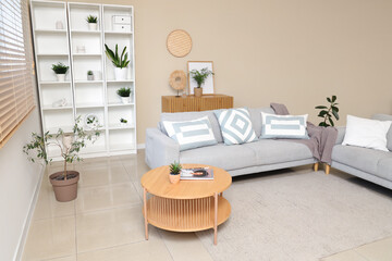 Poster - Interior of stylish living room with comfortable sofa, coffee table, shelving unit and houseplant