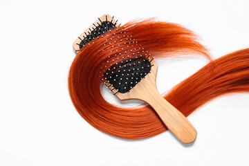 Wall Mural - Hairbrush and red hair strand on white background, closeup