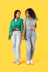 Poster - Young lesbian couple holding hands on yellow background