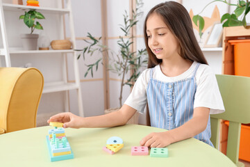 Poster - Cute little girl with building blocks on table at home