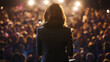 © Валерія Дємідова - woman in suit with brown hair performing in front of giant crowd of people, view from behind