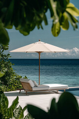 Poster - A sun lounger with cosy cushions under the shade of palm trees on a sandy beach with the blue ocean in the background