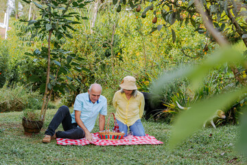 Couple setting up their things for a family picnic day. People smiling.