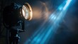© buraratn - A close-up of a stage spotlight with a focused beam illuminating the dark surroundings