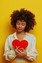 Poster - A woman holds a bright red heart in her hands