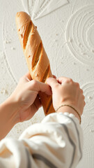 Close-up of a baker's hands holding a freshly baked baguette