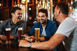 © StarDweller/peopleimages.com - Men, laughing and relax with beer at pub for social gathering, communication and bonding on weekend. Friends, smile and conversation with alcohol beverage for happy hour, drinks or reunion together