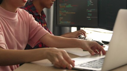 Slow motion back end software developer engineer for computer programming working together on debugging writing computing code, solving complex algorithms display on monitor in office. Burgeoning