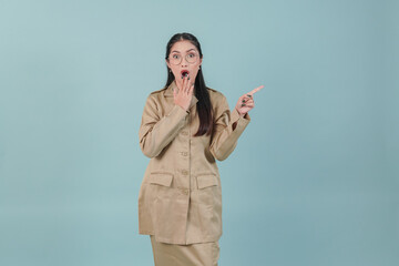 Wall Mural - Young government worker woman pointing to the copy space beside her with shocked expression.