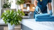 © Lens Legacy - A hotel staff member in blue uniform and gloves cleaning a neatly arranged hotel room with a vacuum cleaner, with a green potted plant on the side table.