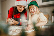 © La Famiglia - Mother and cute little daughter creating a Christmas cookies together