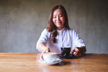 Wall Mural - Portrait image of a young woman holding and serving two cups of coffee