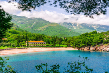 awesome landscape of sea gulf with beautiful turquoise water with amazing green forest shore wwith pakr and hotel and nice green mountains on background